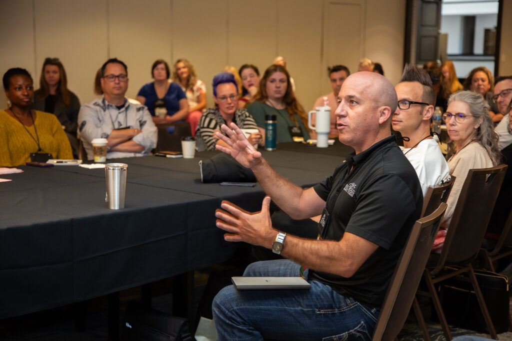Man speaking passionately during a meeting with attentive audience.